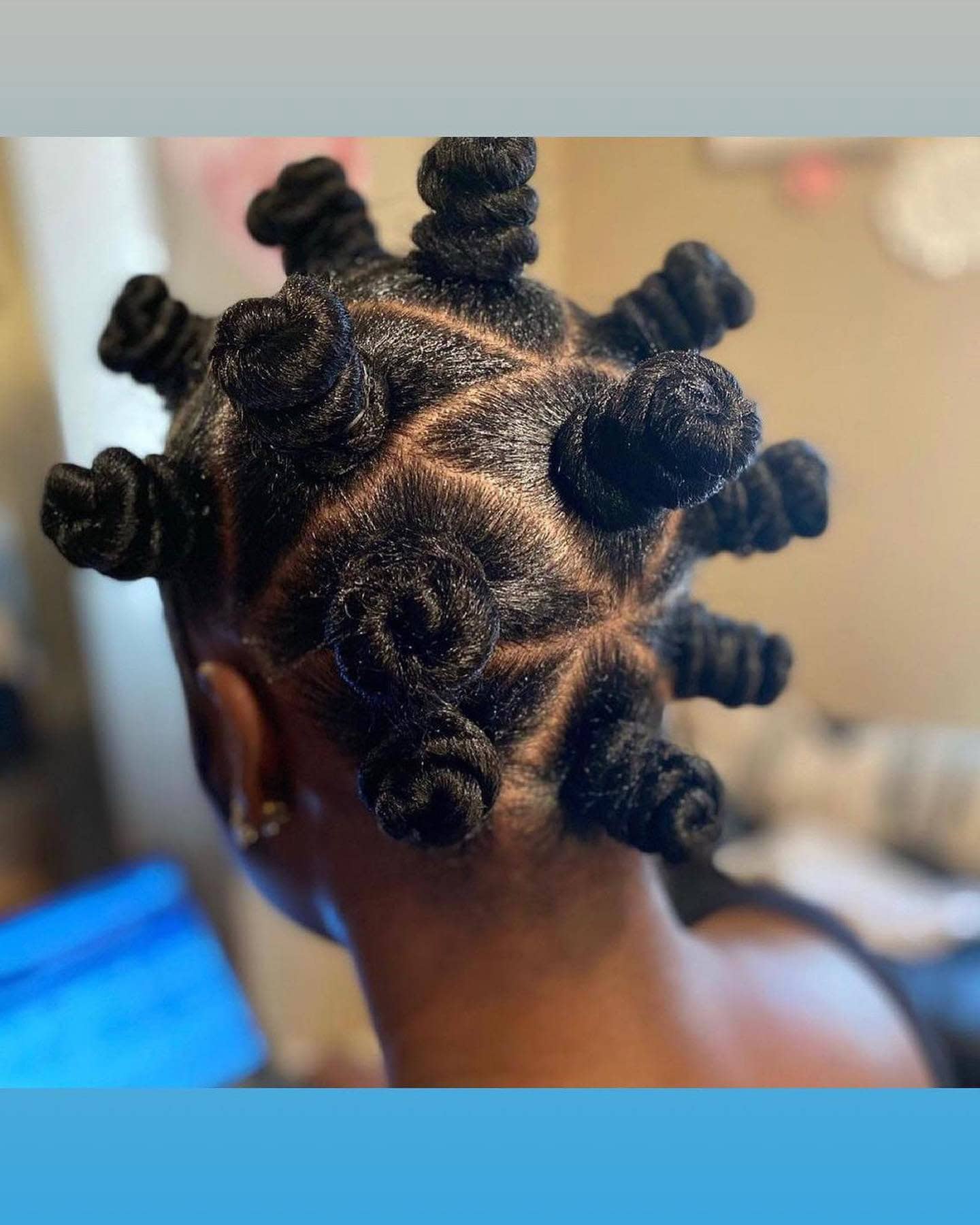 Close-up of a person with Bantu knots, showcasing the neatly sectioned hair and the twisted knots.