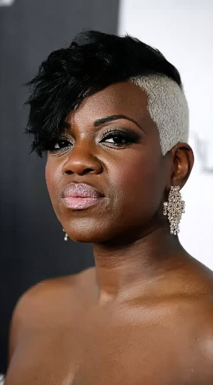 Black woman with a dark wavy cropped top and a contrasting platinum shaved side.