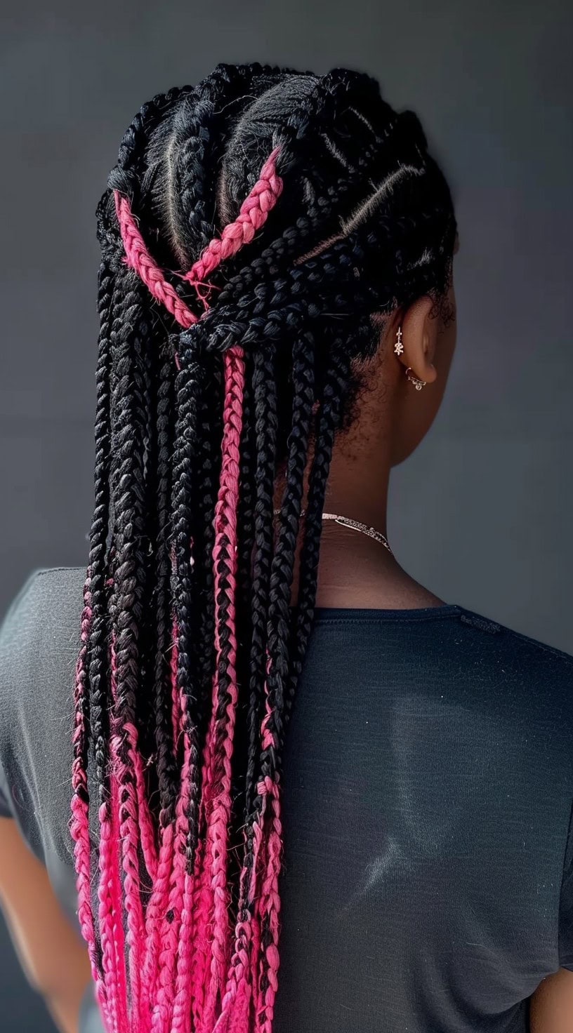 In this photo, a woman with a half-up braided style features pink peekaboo highlights.