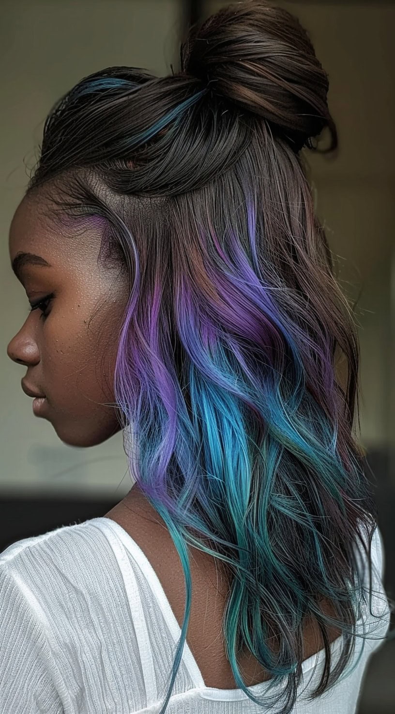 In this photo, a woman with half-up wavy hair features purple and blue highlights.