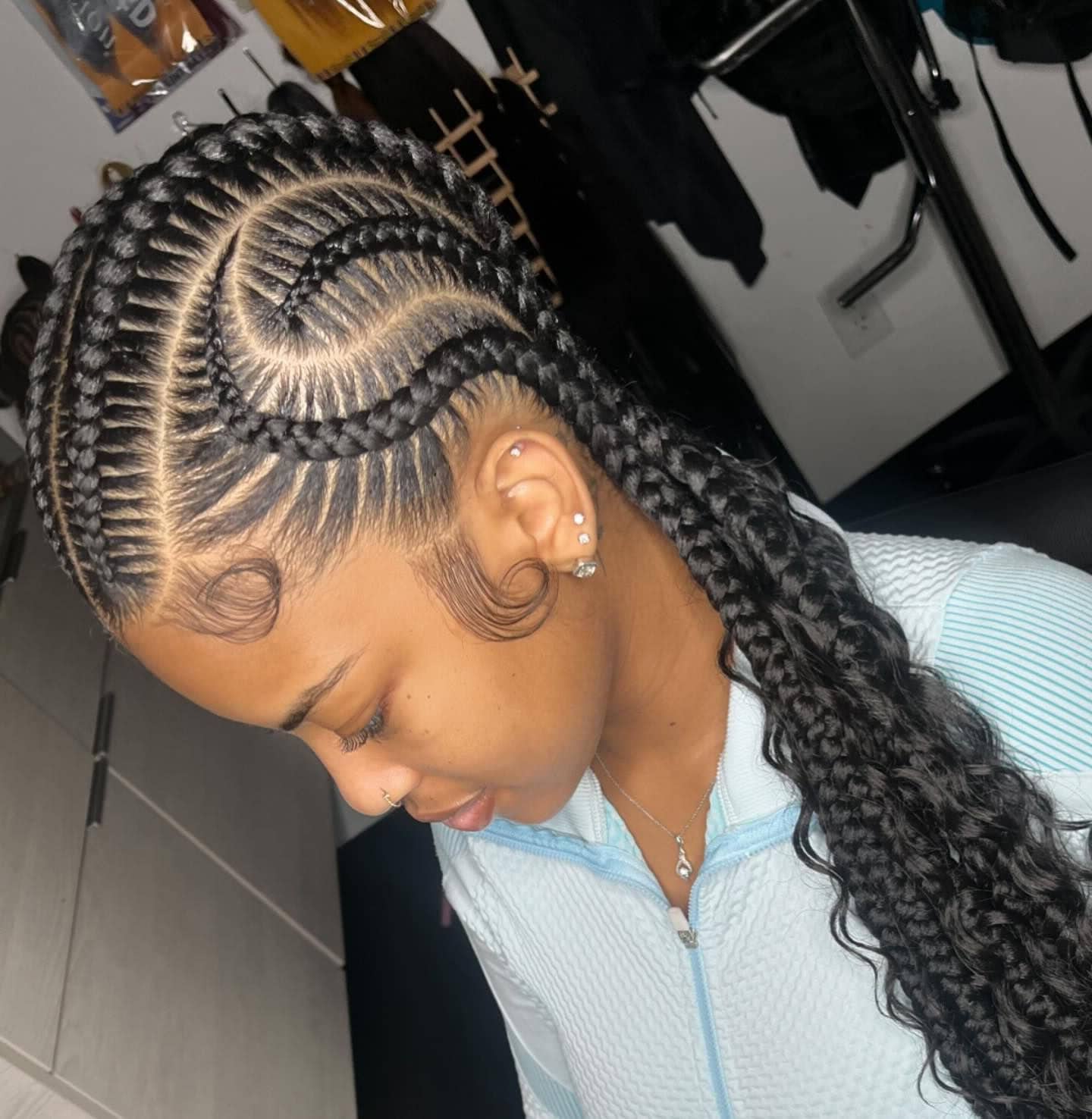 Close-up of a person with intricate cornrows, showcasing detailed patterns and sleek edges.