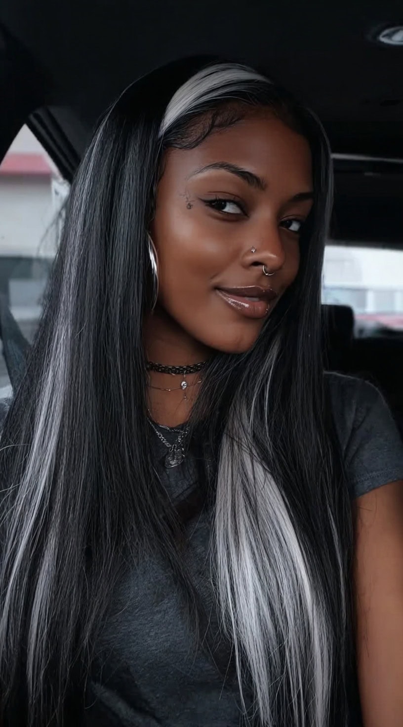 Young woman with long straight black hair featuring ash-blonde peekaboo highlights framing the face.
