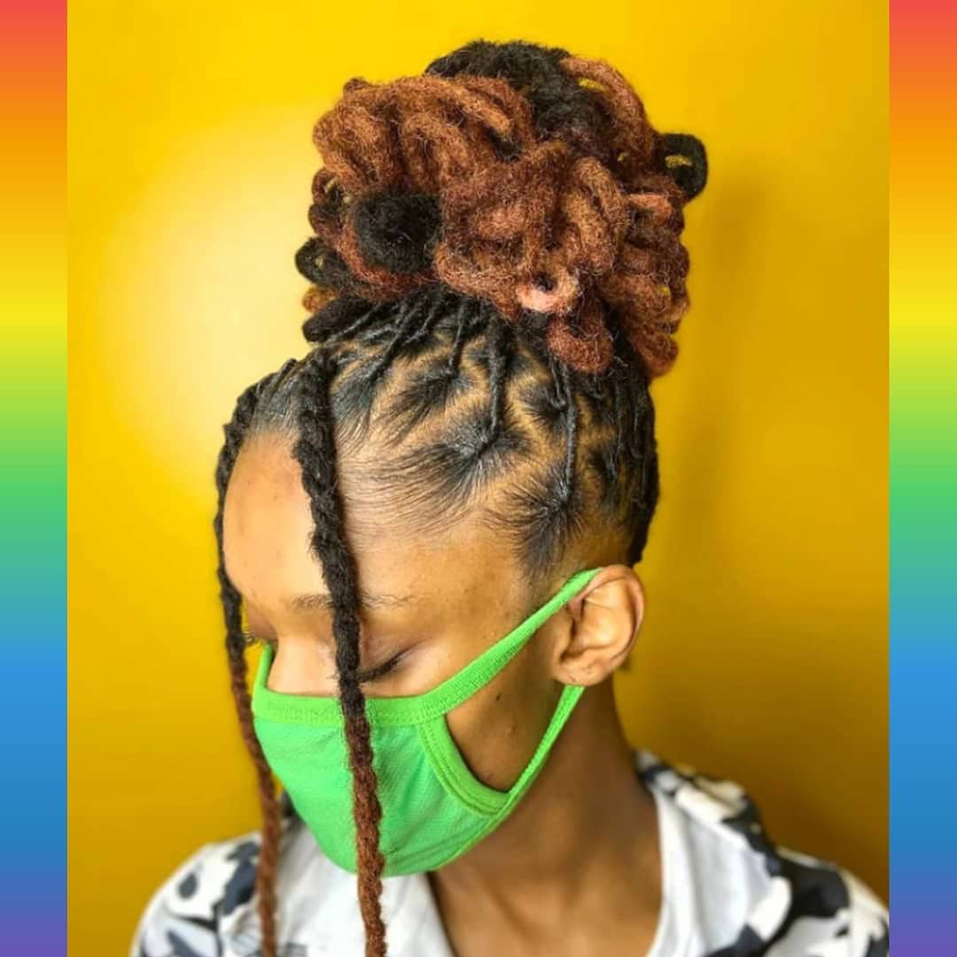 Side view of a person with a high bun, featuring a mix of locs in two different colors.