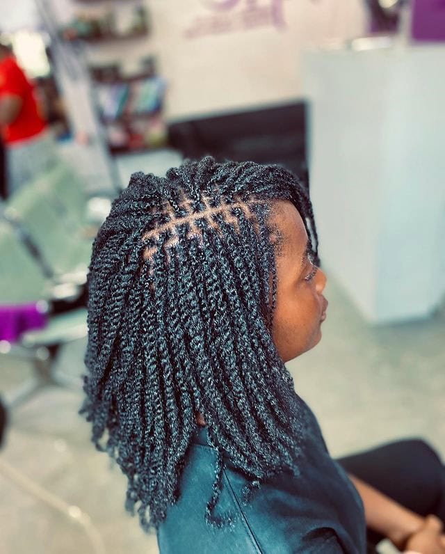 Side view of a person with mini twists, showcasing the small, neatly twisted sections.