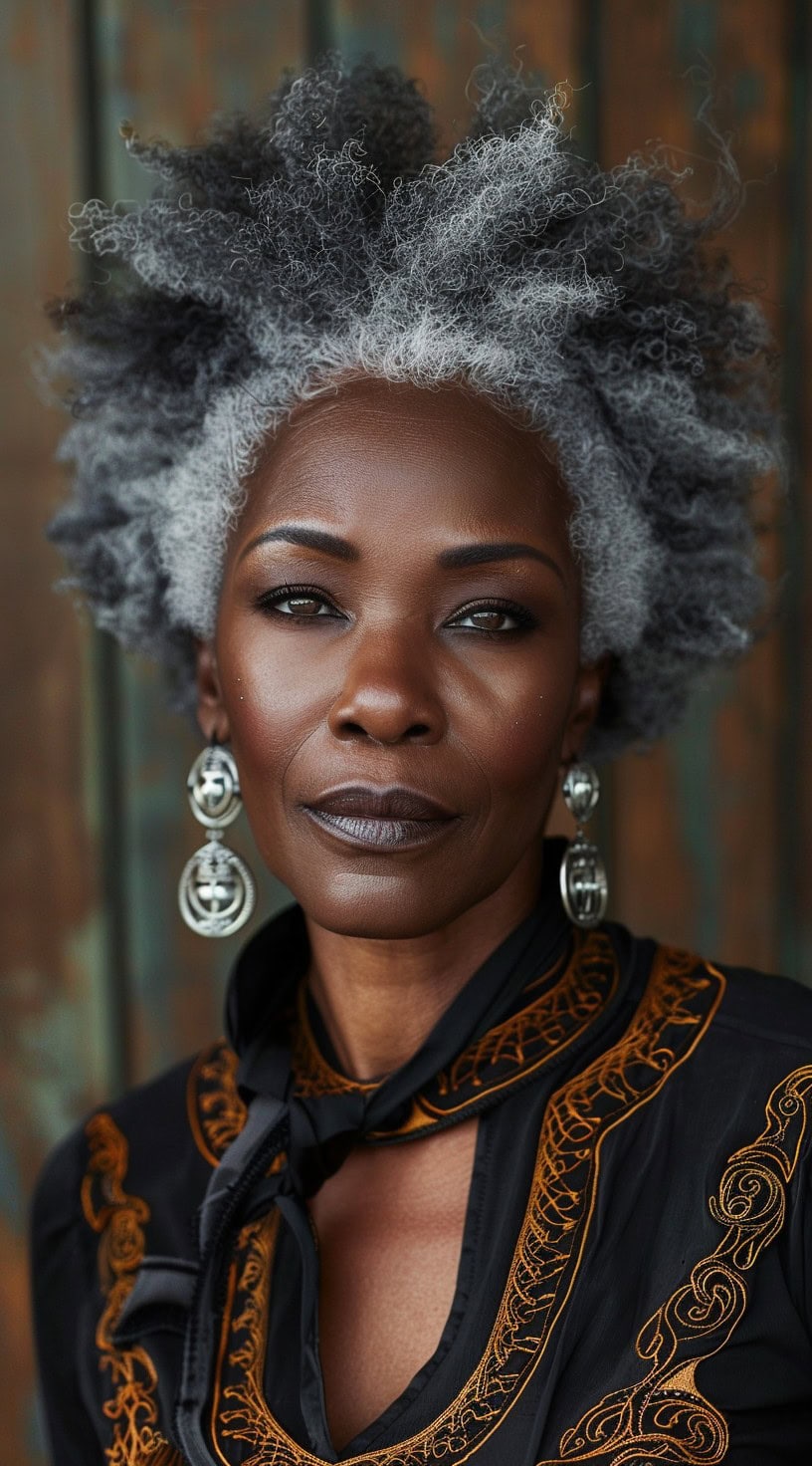 In this photo, a woman with natural silver coils poses against a wooden background.