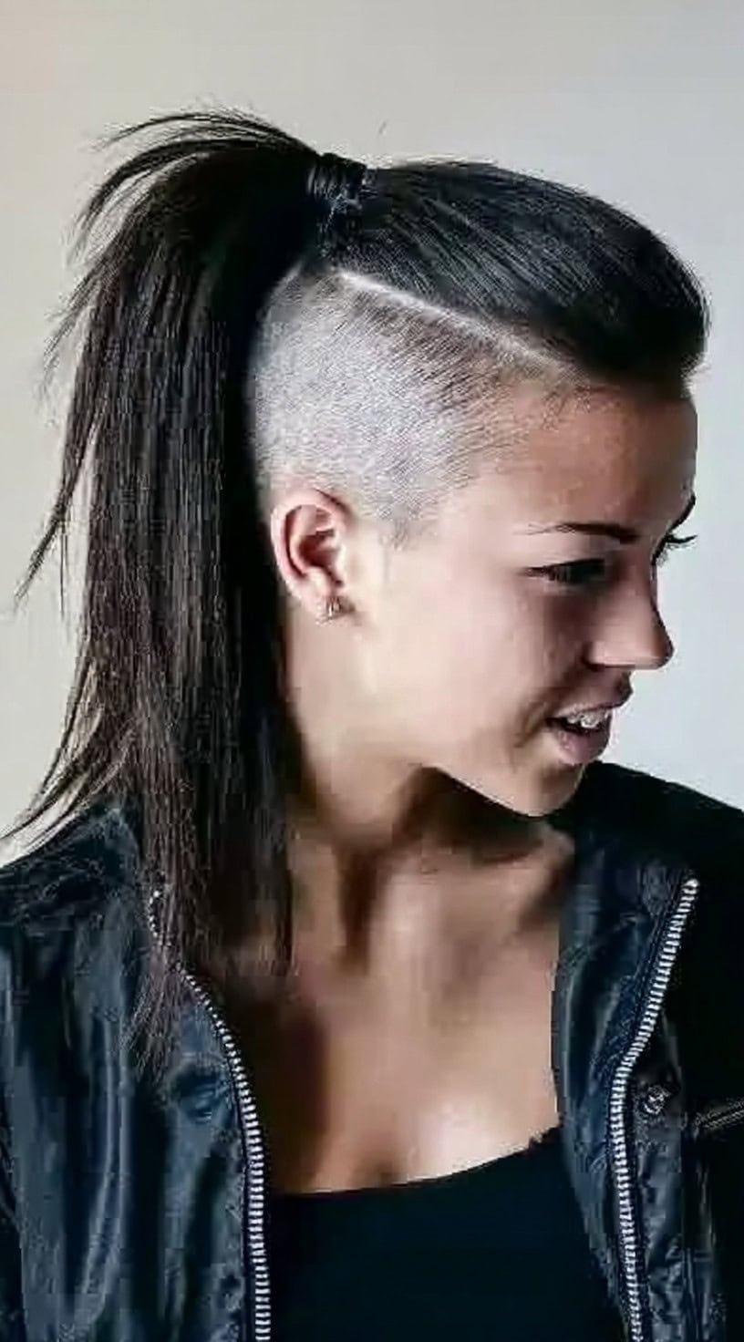 Woman wearing a sleek high ponytail that exposes a sharply defined undercut on both sides.