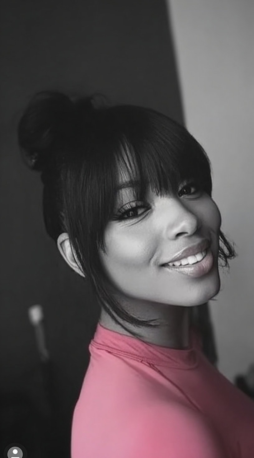 Smiling woman wearing a soft updo-style weave ponytail with full wispy bangs.