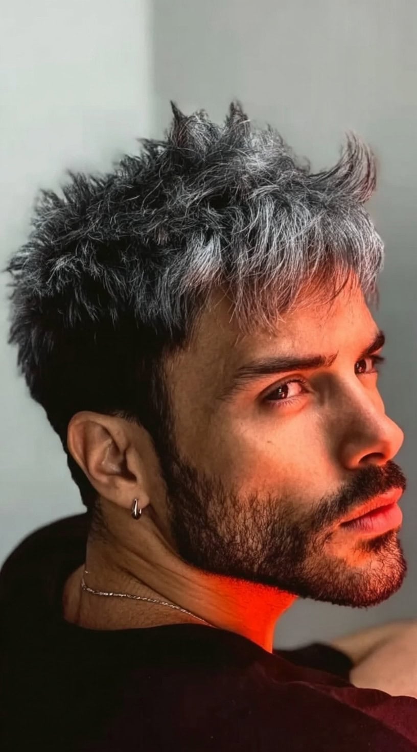 Man with tousled silver-white hair on top and darker natural roots showing through.
