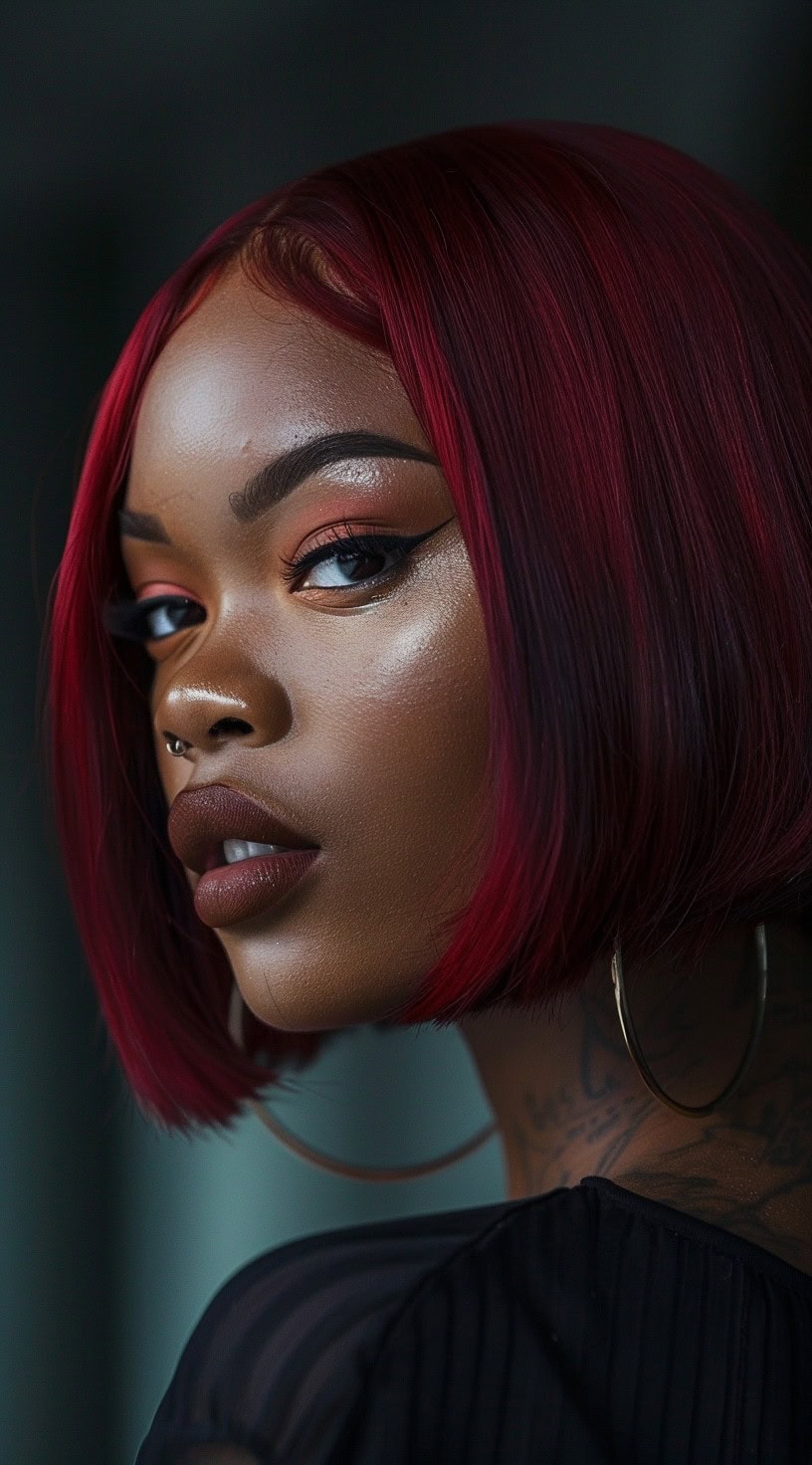 This image features a woman with dark skin and a blunt cut red bob, showing a sleek and modern look.