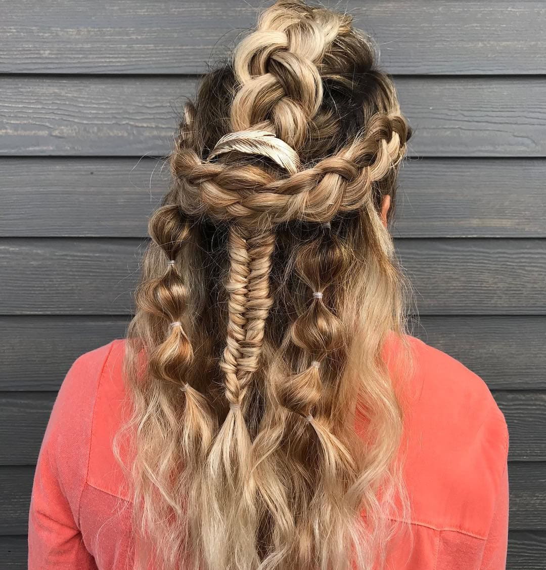 This image depicts a boho hairstyle featuring a fishtail braid with side bubble pigtails.