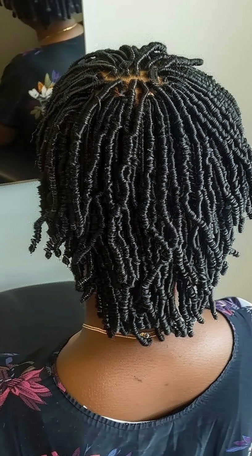 Back view of a woman with short finger coils.