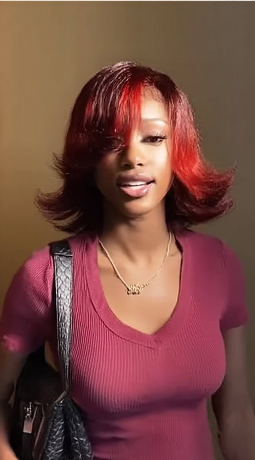 A red bob with soft bangs and flipped-out ends creating a playful, retro-inspired shape.