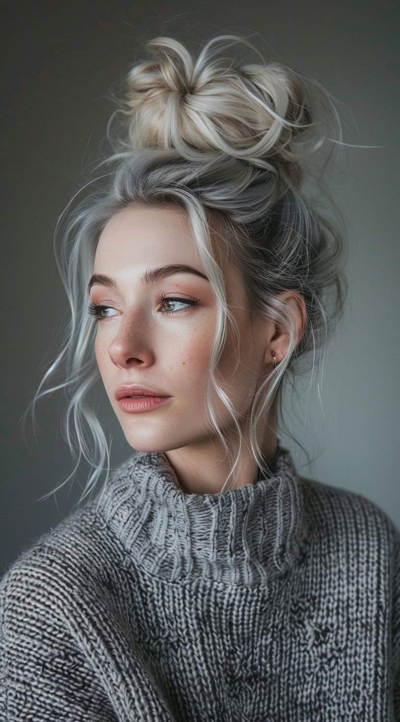 In this photo, a woman with platinum blonde hair styled in a top knot and loose tendrils around her face is shown.