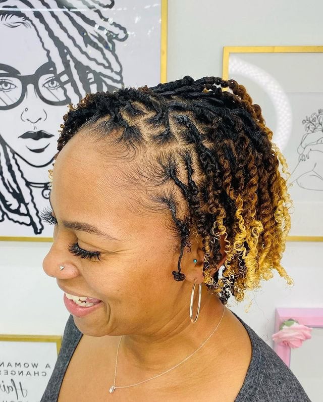 A woman with short two-strand twist locs featuring alternate ombre coloring.