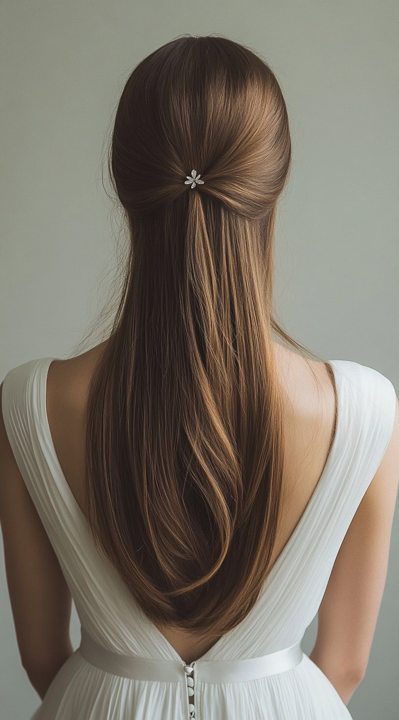 A rear view of a woman with an elegant half-up twist, secured with a decorative barrette.