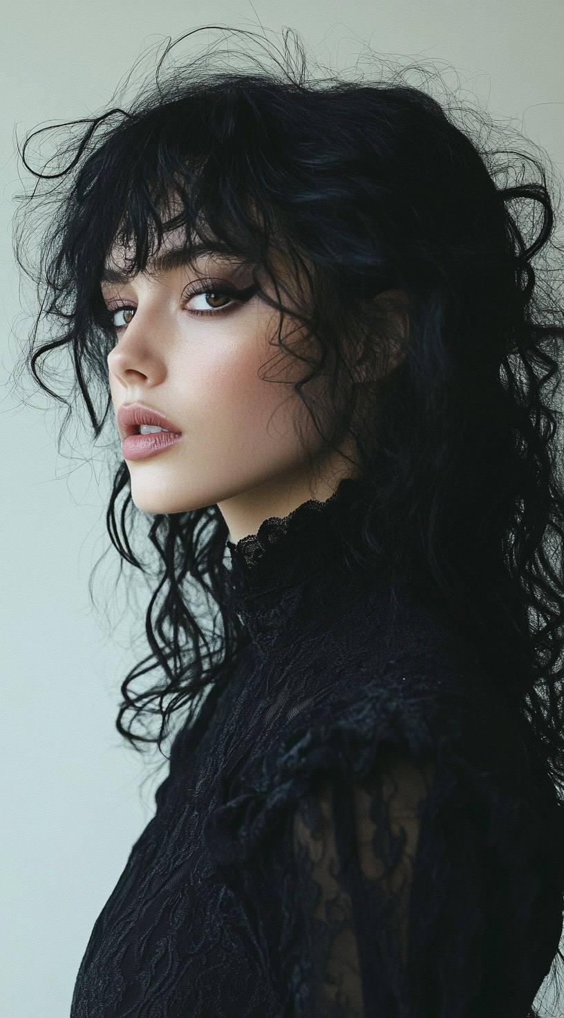 This photo depicts a woman with wild, textured messy curls and bangs.