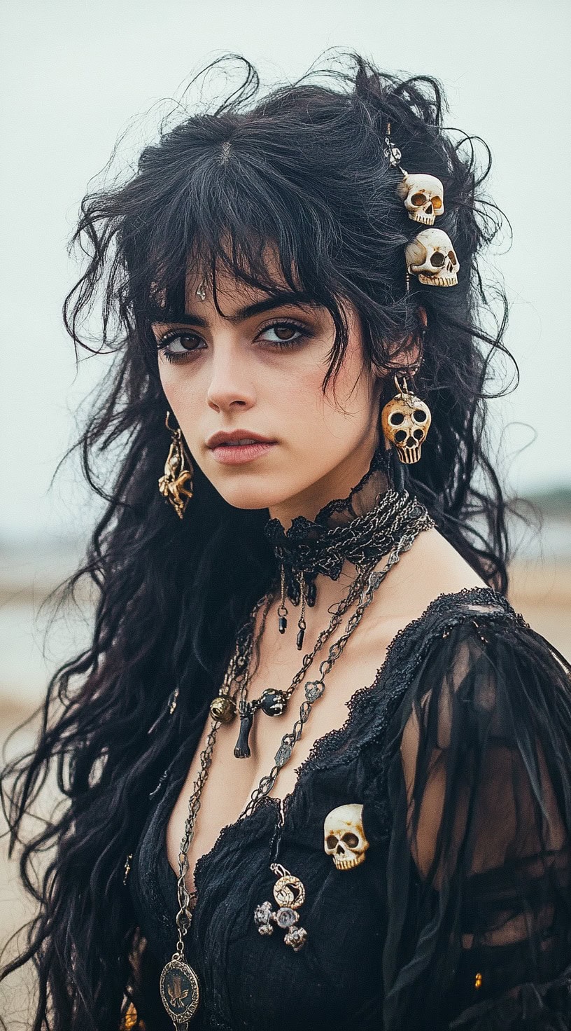 Young woman with wispy waves, bangs, and skull hair jewelry standing by the beach.