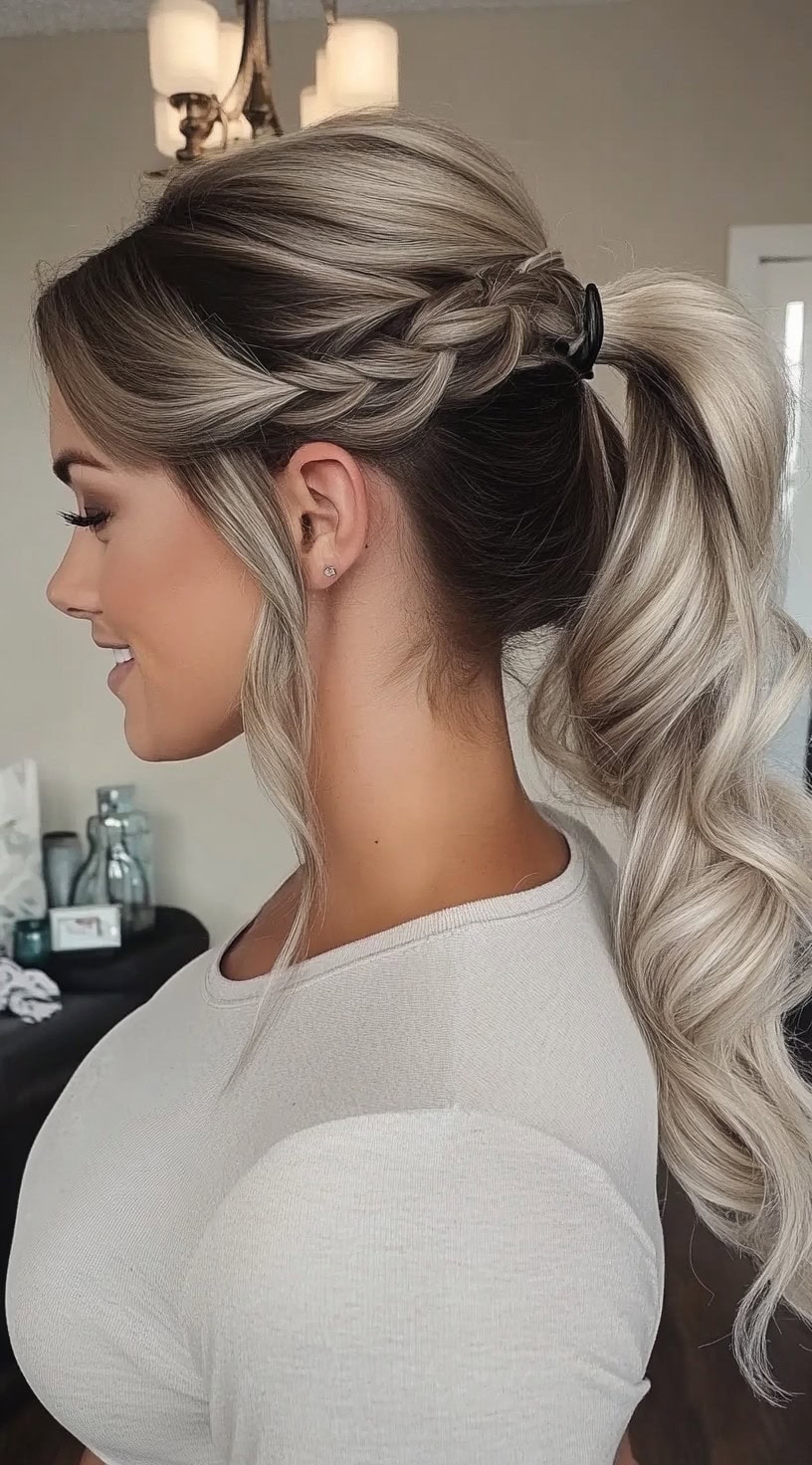 A woman with a high, wavy ponytail featuring a side braid detail, blending seamlessly into the hairstyle for an intricate finish.