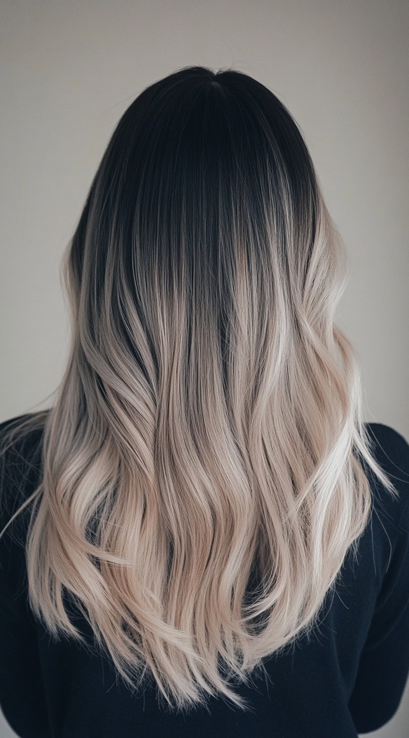 Straight, sleek ash blonde balayage with jet black roots.