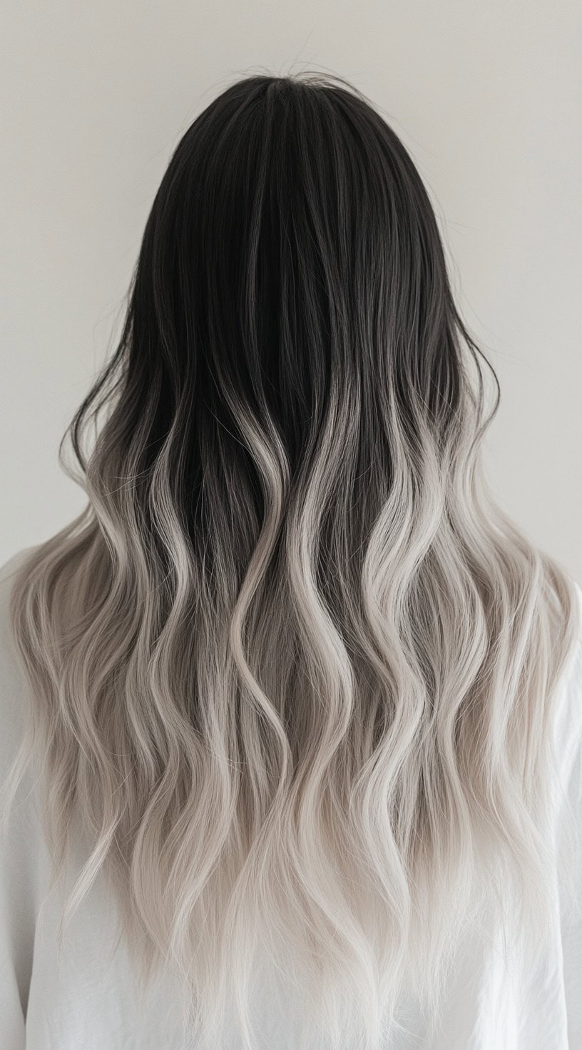 Long wavy hair transitioning from dark roots to ash blonde ends.