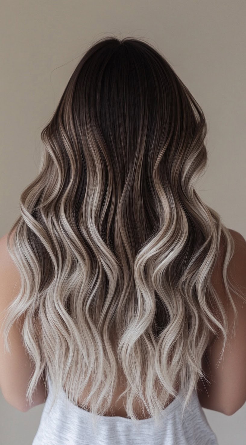 Long wavy hair with a brunette base blending into ash blonde.