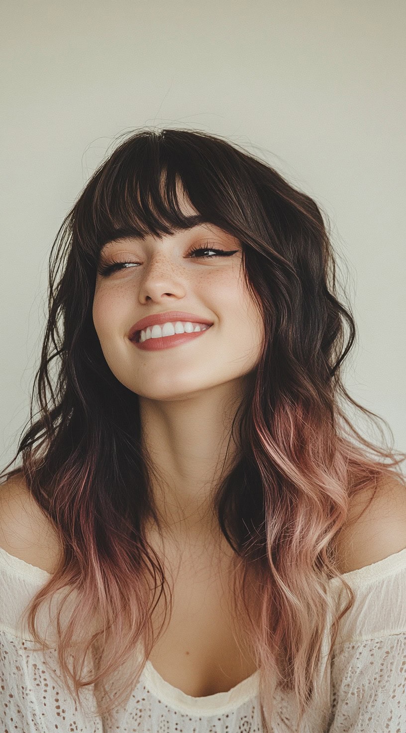 A front view of tousled, mid-length dark brown hair with soft blush pink strawberry blonde ombre highlights.