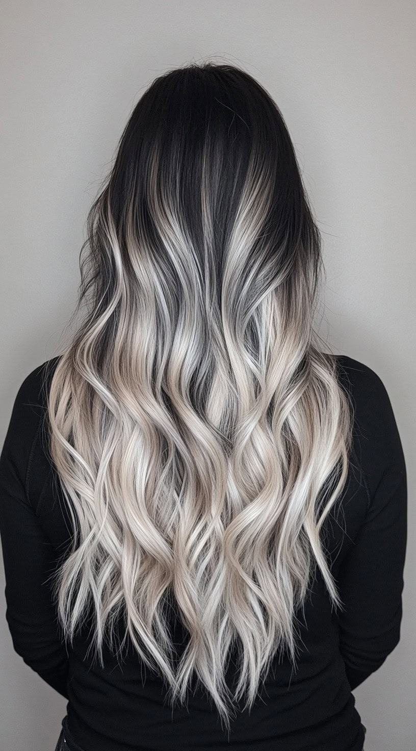 Long, wavy ash blonde hair with dark, almost black roots.