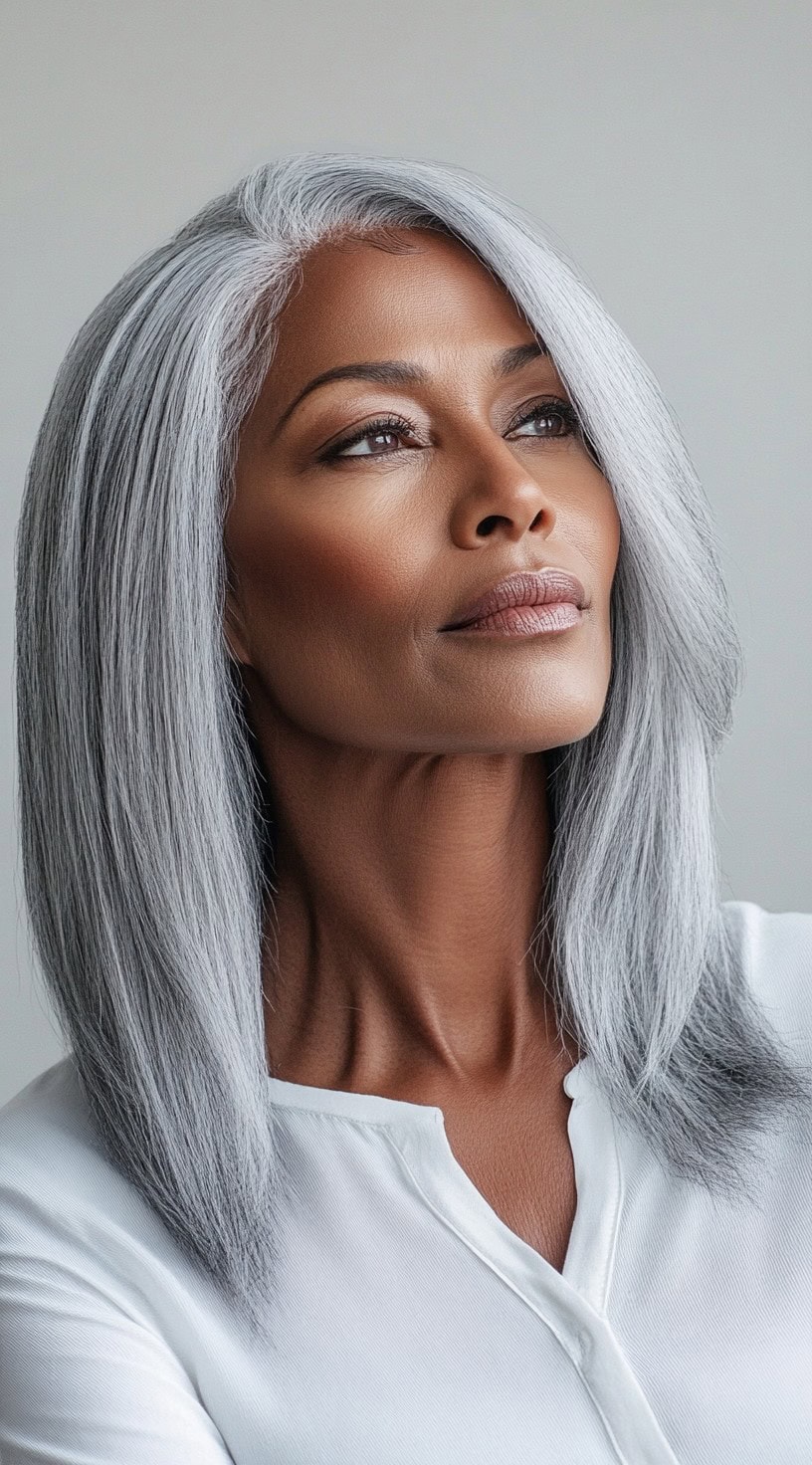 A graceful older Black woman with a sleek, shoulder-length silver lob, styled with a soft side part, wearing a crisp white blouse.