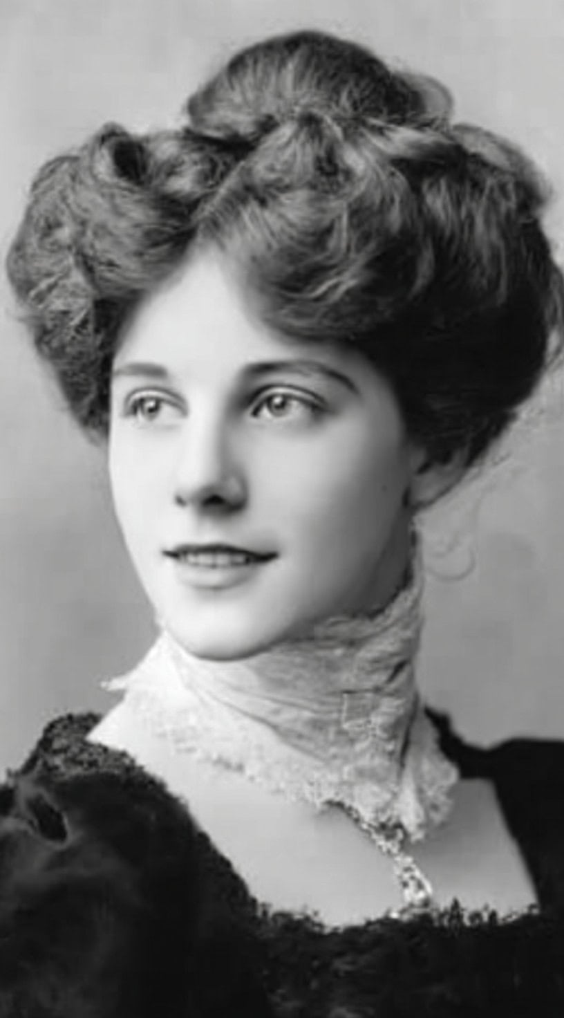 Black-and-white portrait of a woman with voluminous hair styled in an Edwardian puffed pompadour.